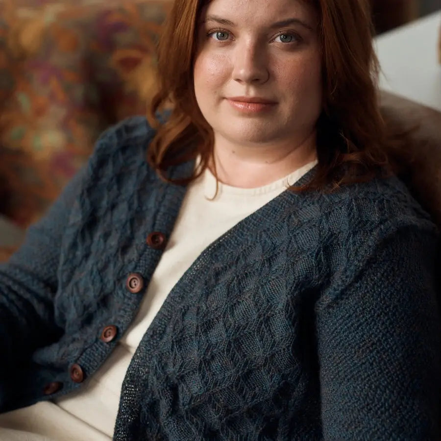 Woman wearing a blue knitted cardigan with a blurred background