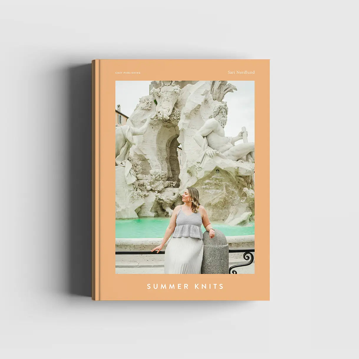 Book cover with a woman in a fountain and 'Summer Knits' text