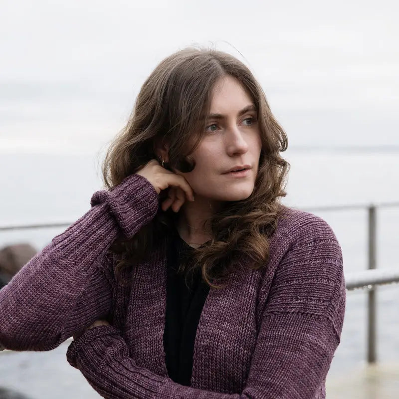 a woman wearing a purple cardigan