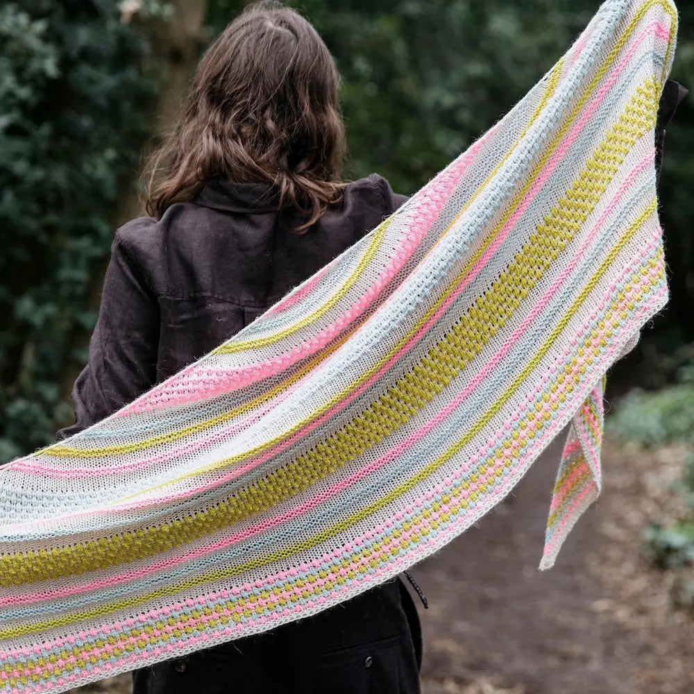Person wearing a colorful striped shawl outdoors