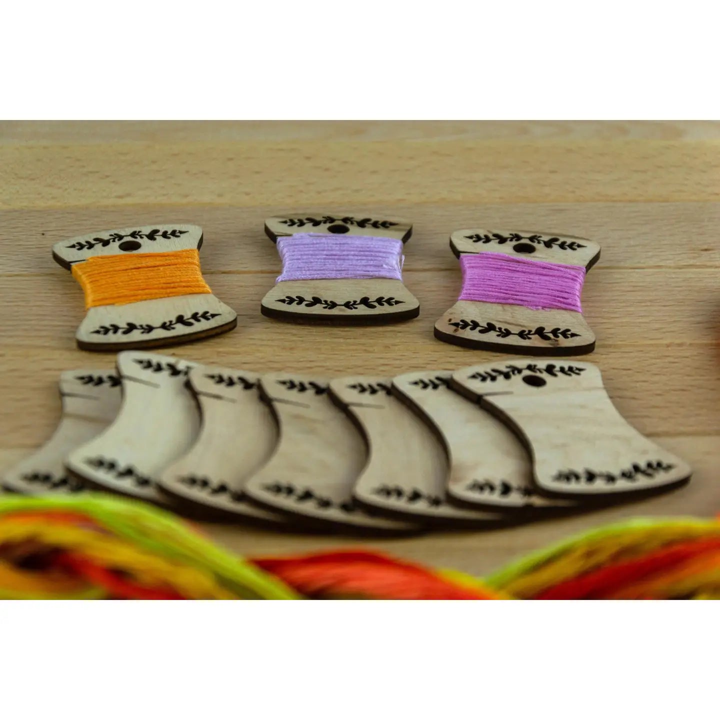 a set of ten wooden embroidery bobbins