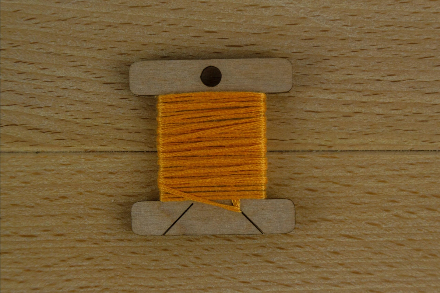 one wooden thread bobin wrapped with orange thread