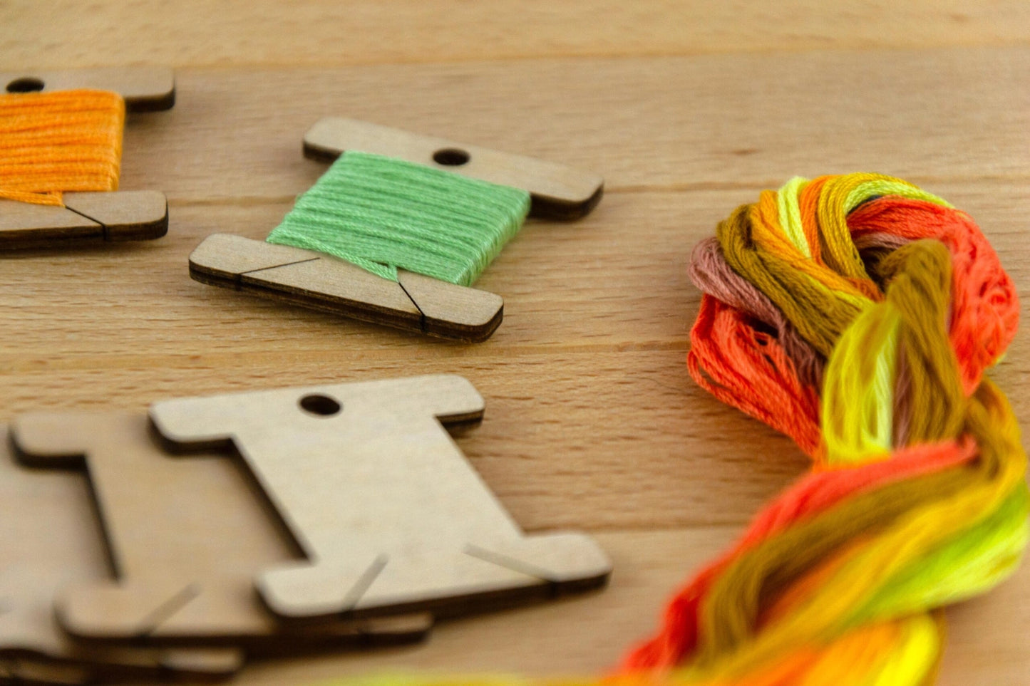a close up of a wooden thread bobbin wrapped in green thread