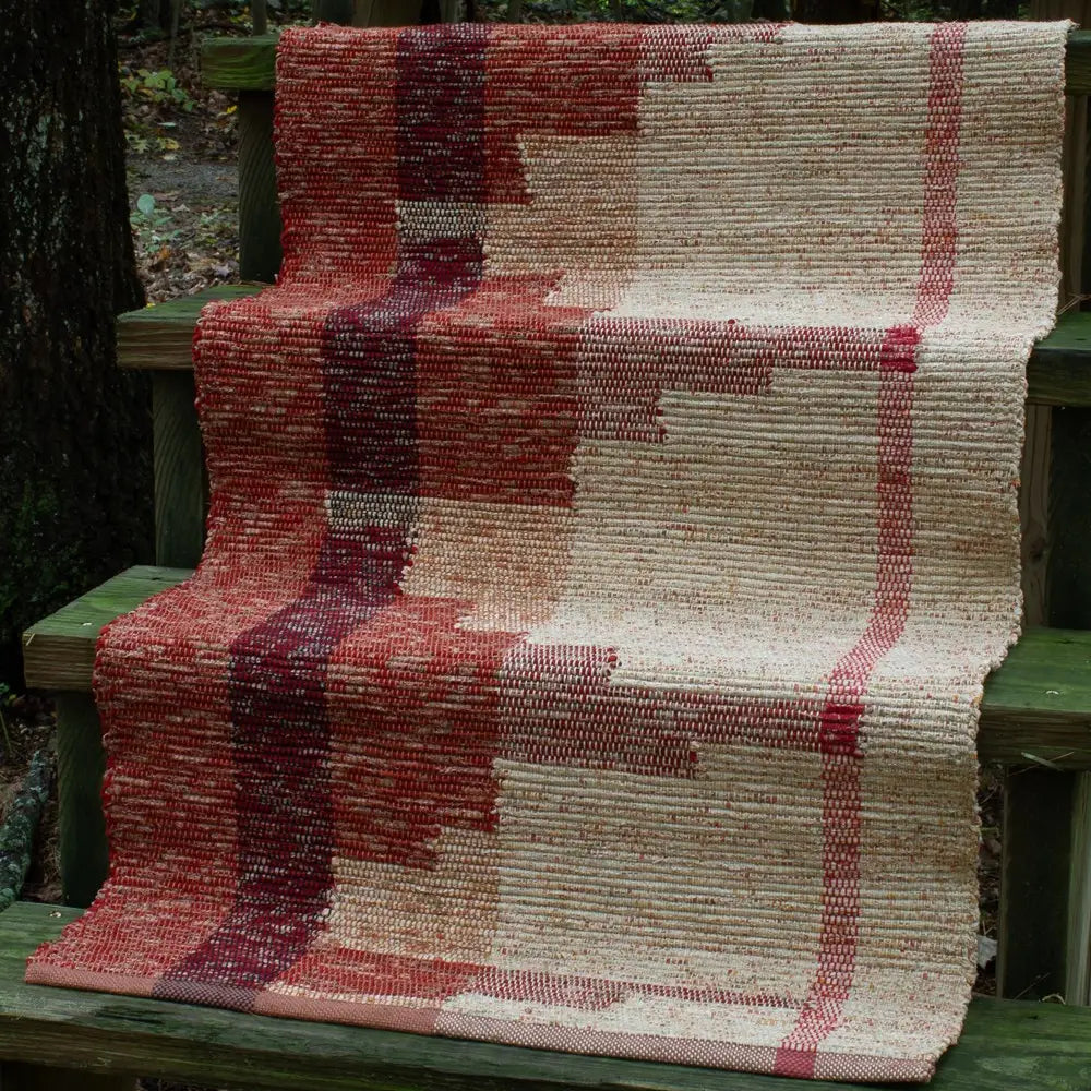 a red and tan woven rug on green stairs