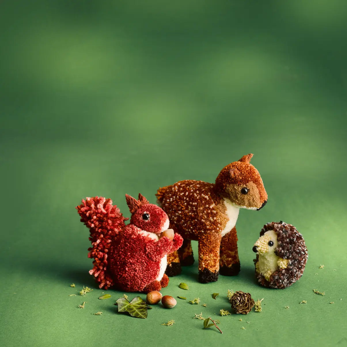 forest animals made of pom pots on a green background