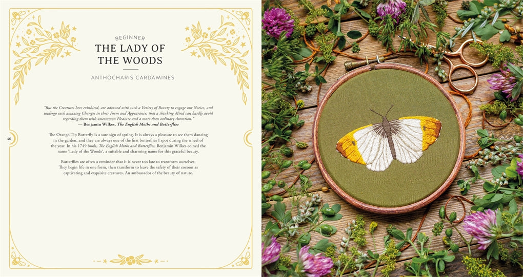 Embroidery of a butterfly in a wooden hoop surrounded by flowers and leaves on a wooden surface.