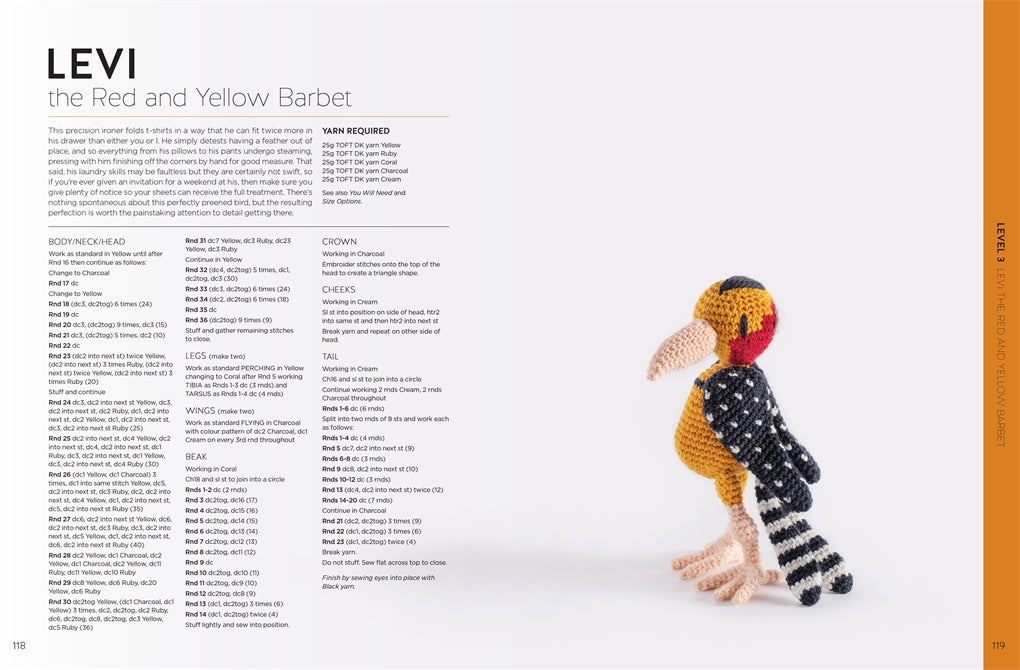 Crocheted barbet toy with red and yellow head and black and white striped body on a white background.