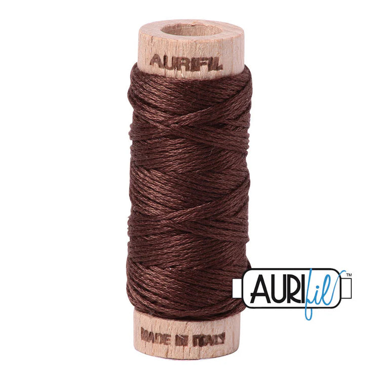A spool of Aurifil 6-strand embroidery floss in brown color, wound around a wooden spool.