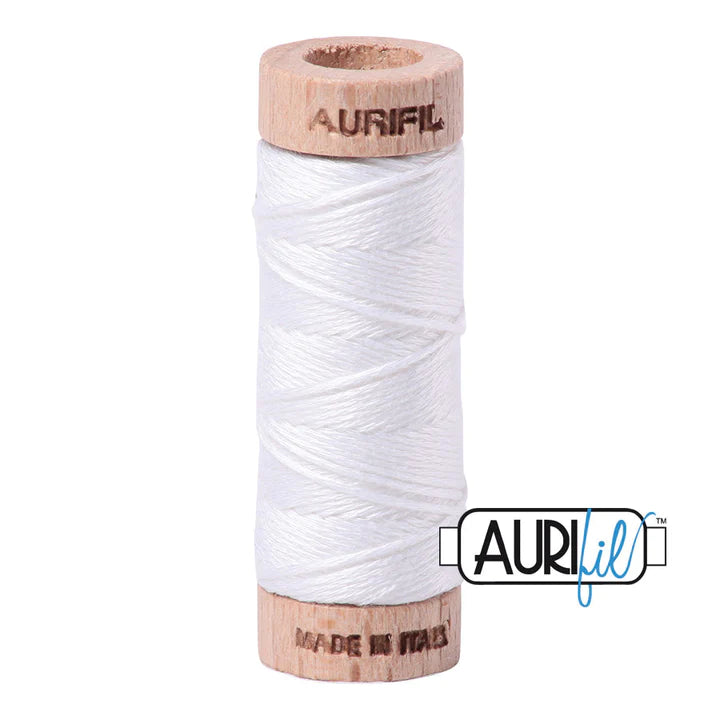 A spool of white Aurifil 6-strand embroidery floss wound around a wooden spool with the brand name visible.
