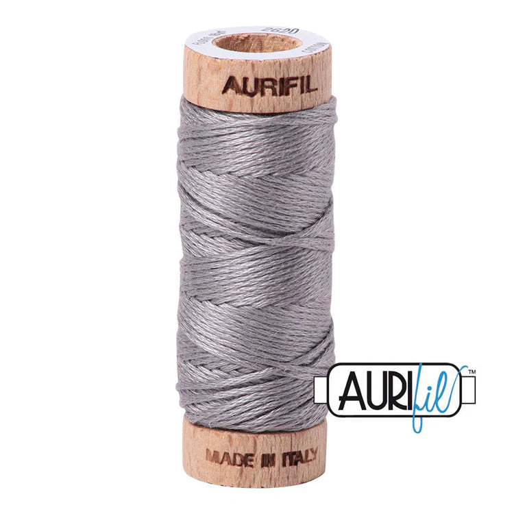 A spool of Aurifil 6-strand embroidery floss in gray, wound around a wooden spool.