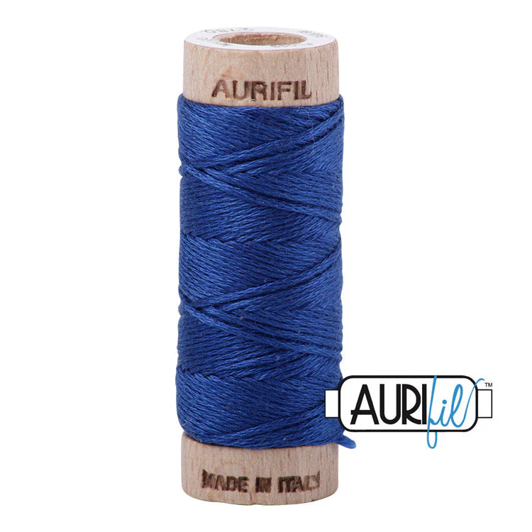 A spool of Aurifil 6-strand embroidery floss in medium blue color, wound around a wooden spool with the brand name visible.