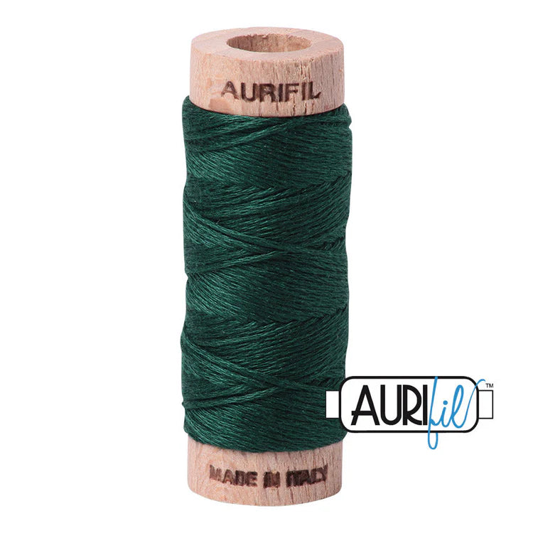A spool of Aurifil 6-strand embroidery floss in dark green color, wound around a wooden spool with the brand name visible.