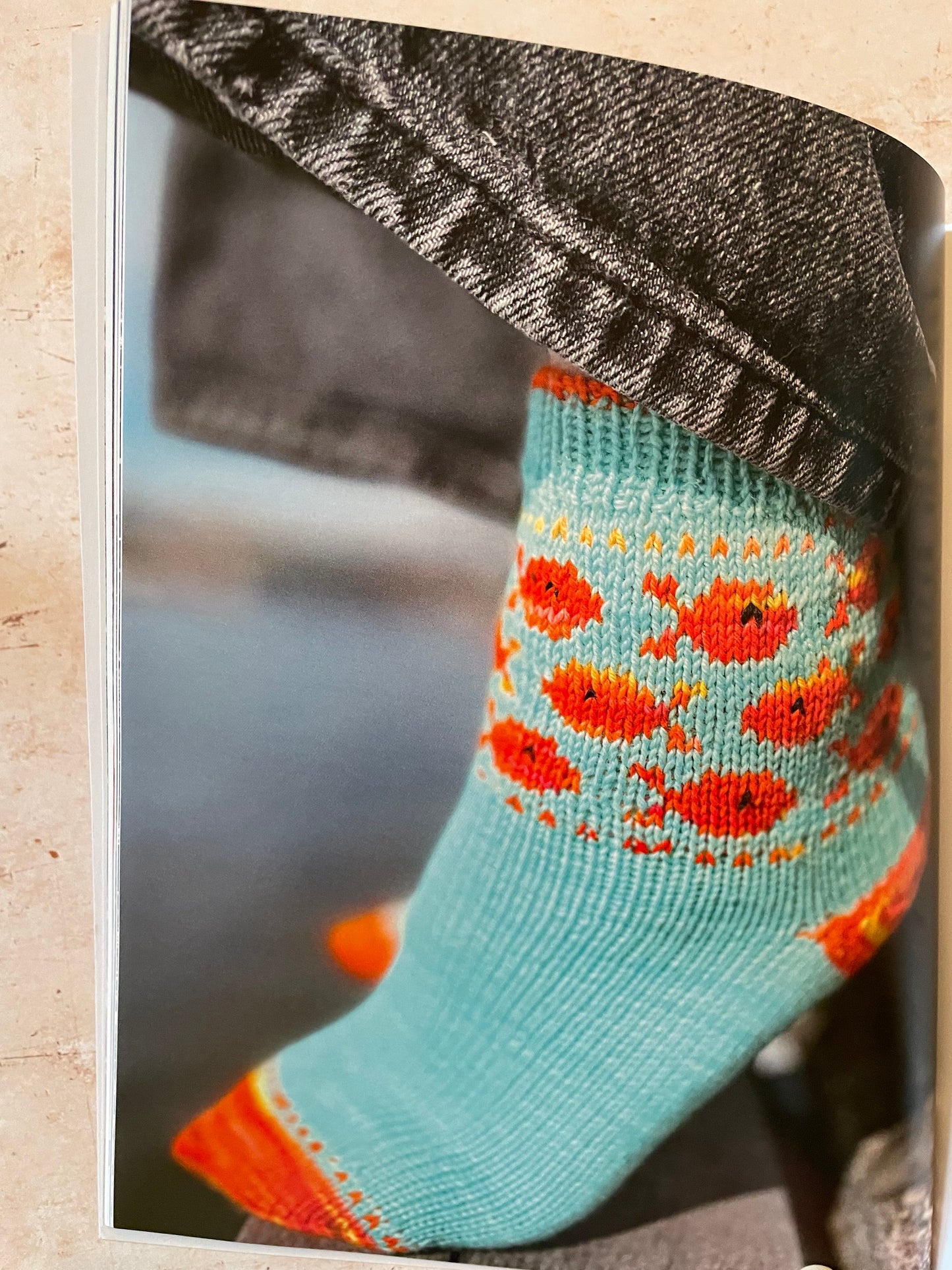 Close-up of a sock with orange fish pattern on a gray background