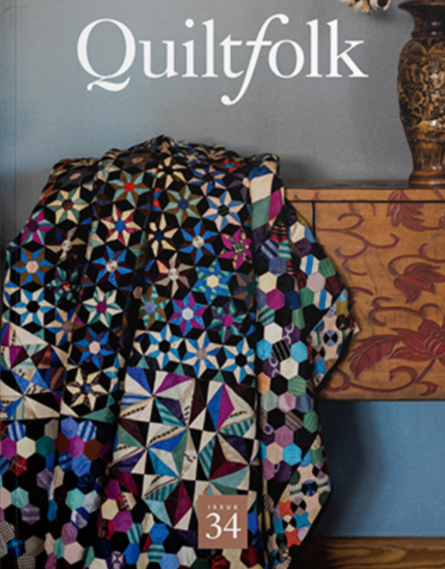 A colorful pinwheel quilt on a black base