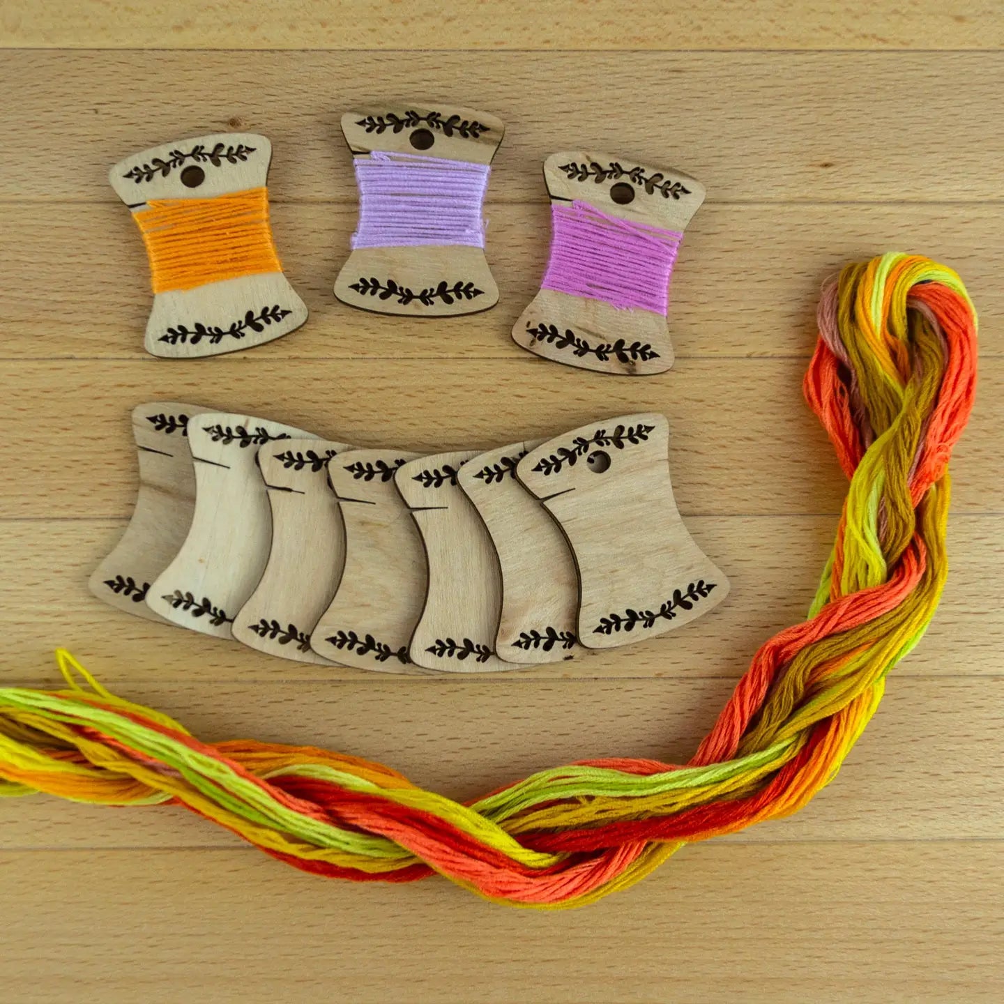 set of 10 wooden bobbins and thread