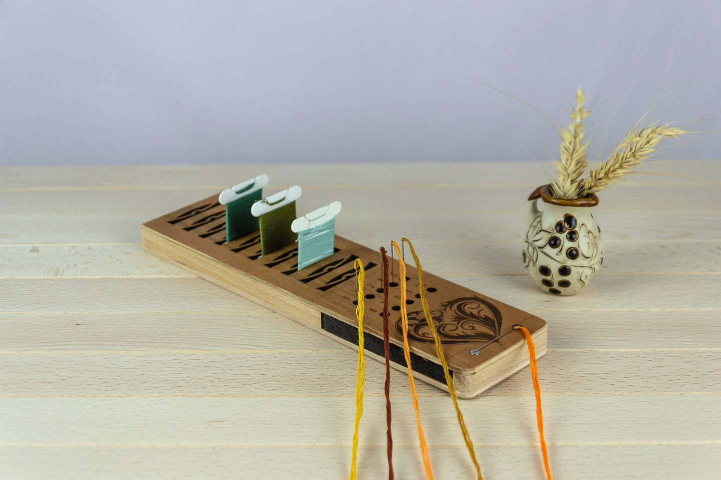 Wooden bobbin holder with colorful thread paper bobbins on a wooden surface.
