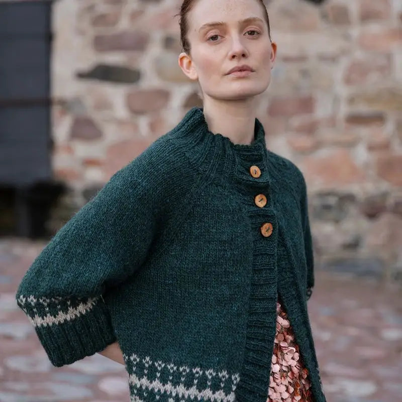 a woman wearing a green and white sweater