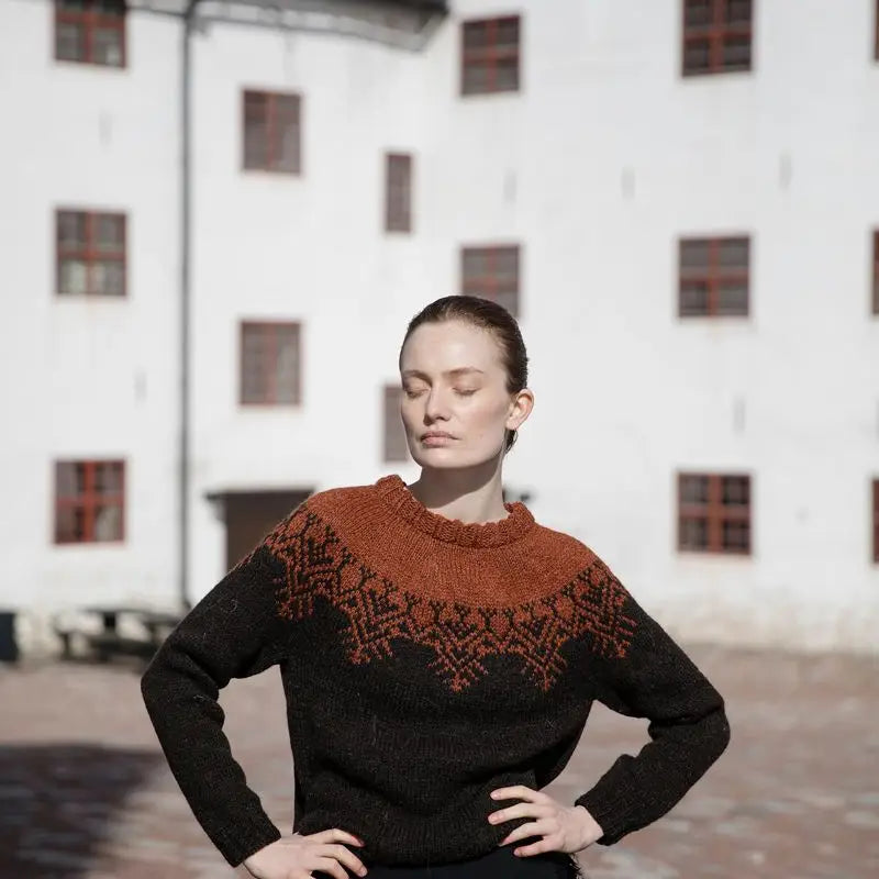 a woman wearing a brown and orange sweater