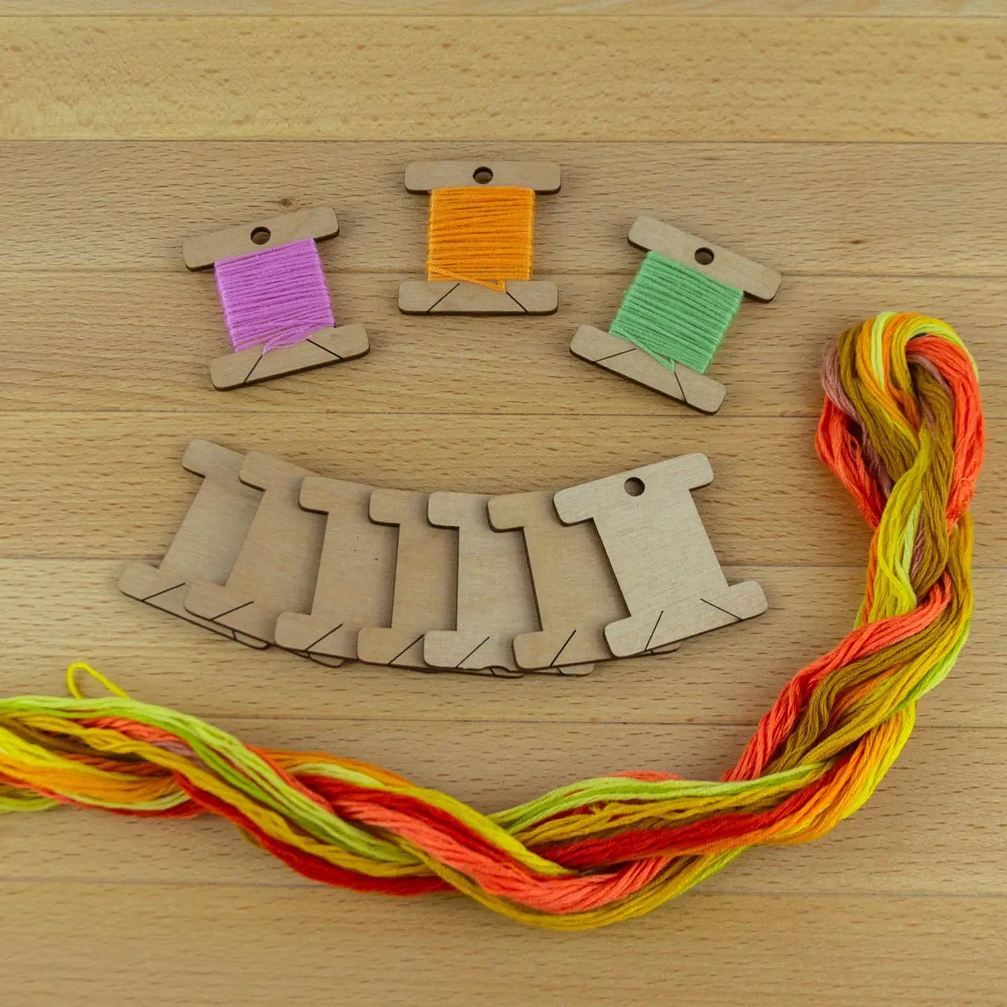 10 wooden thread bobbins on a wooden surface