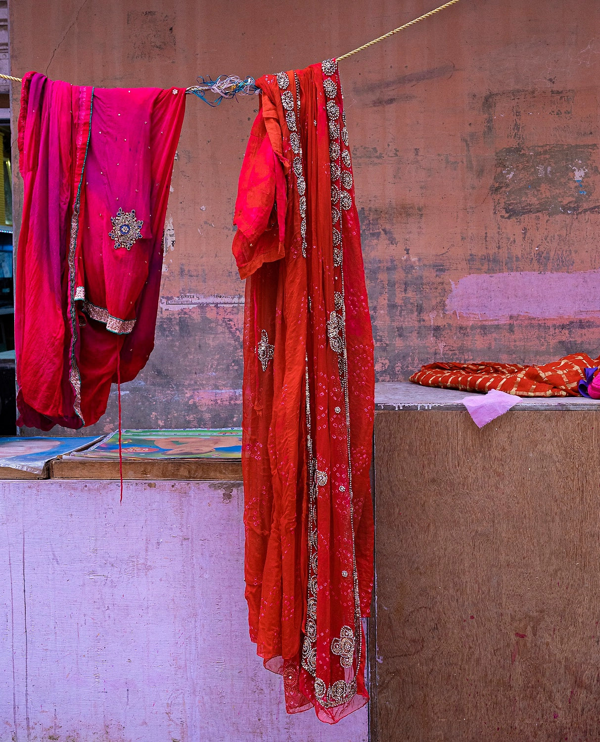 Bright red garments against a purple wall