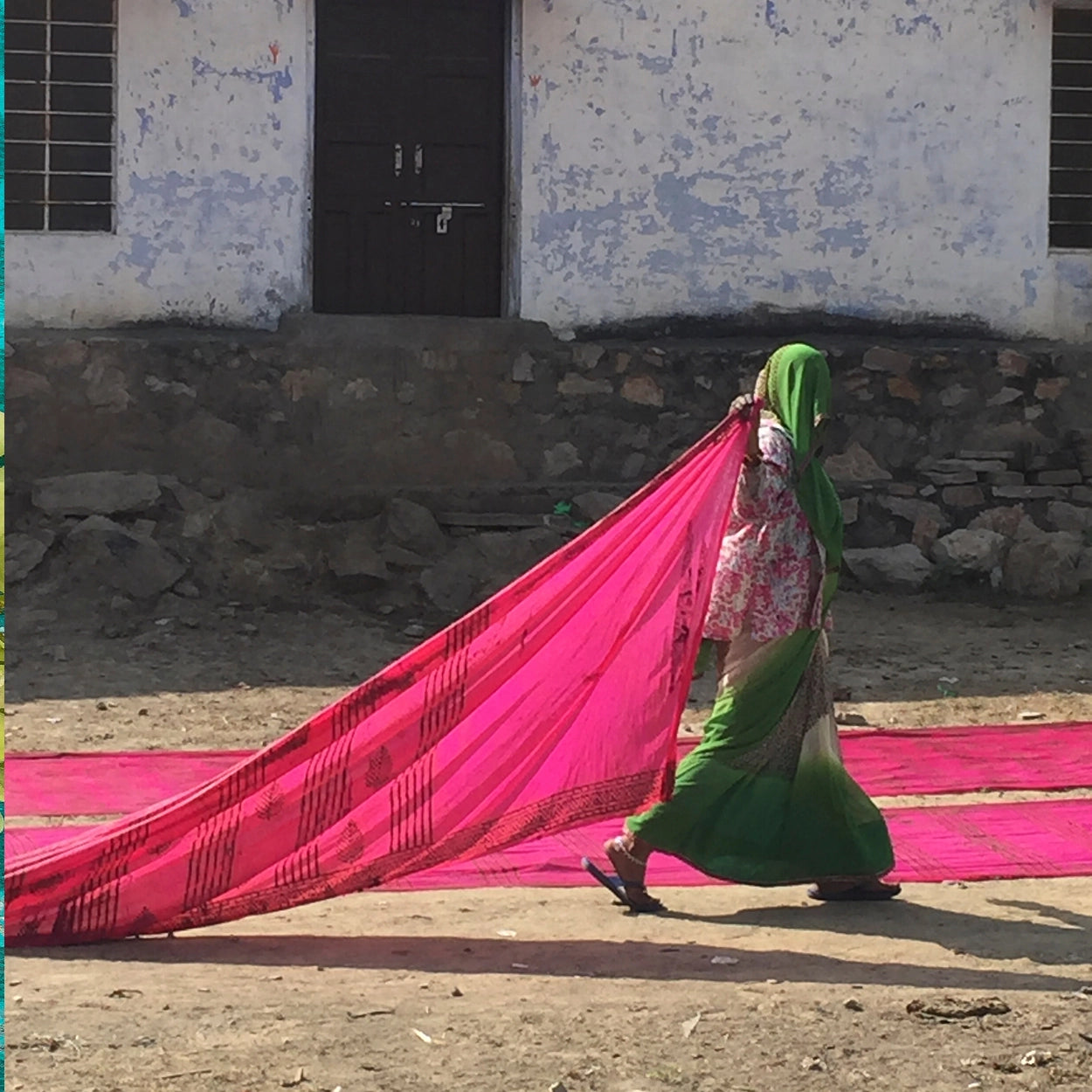 woman in green dress with bright pink cloth