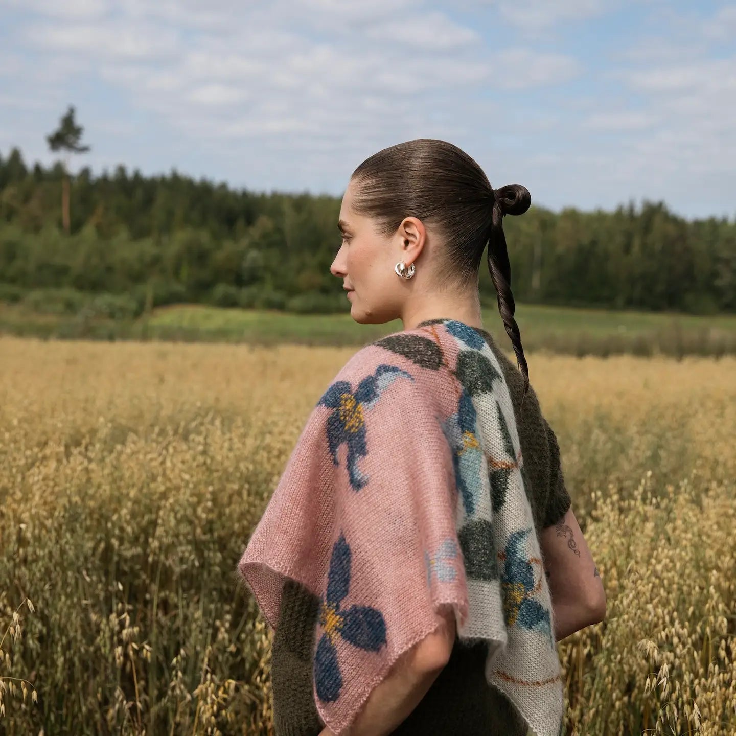 A pink and ream knitted shawl with blue flowers