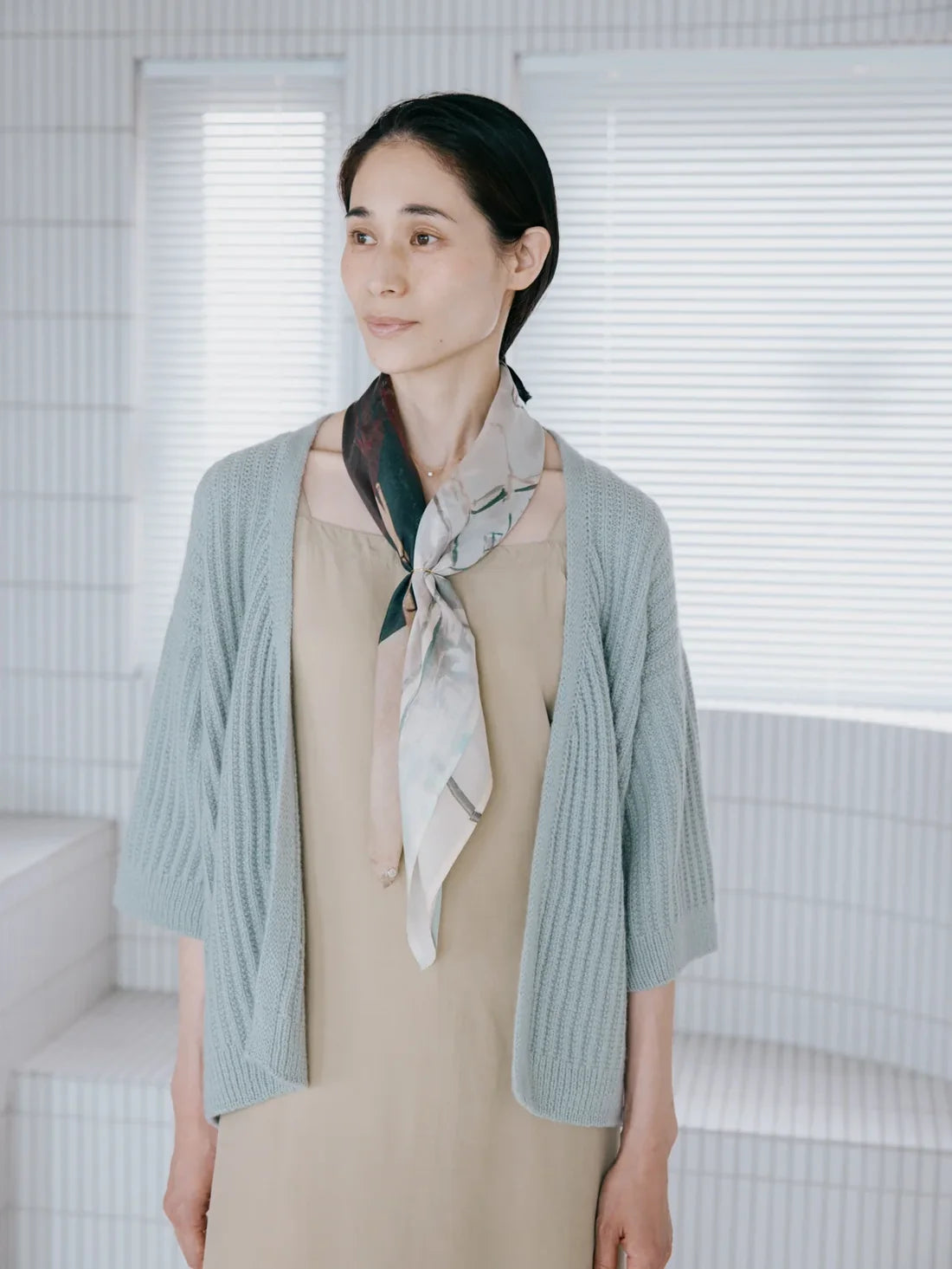 a woman wearing a light blue cardigan sweater