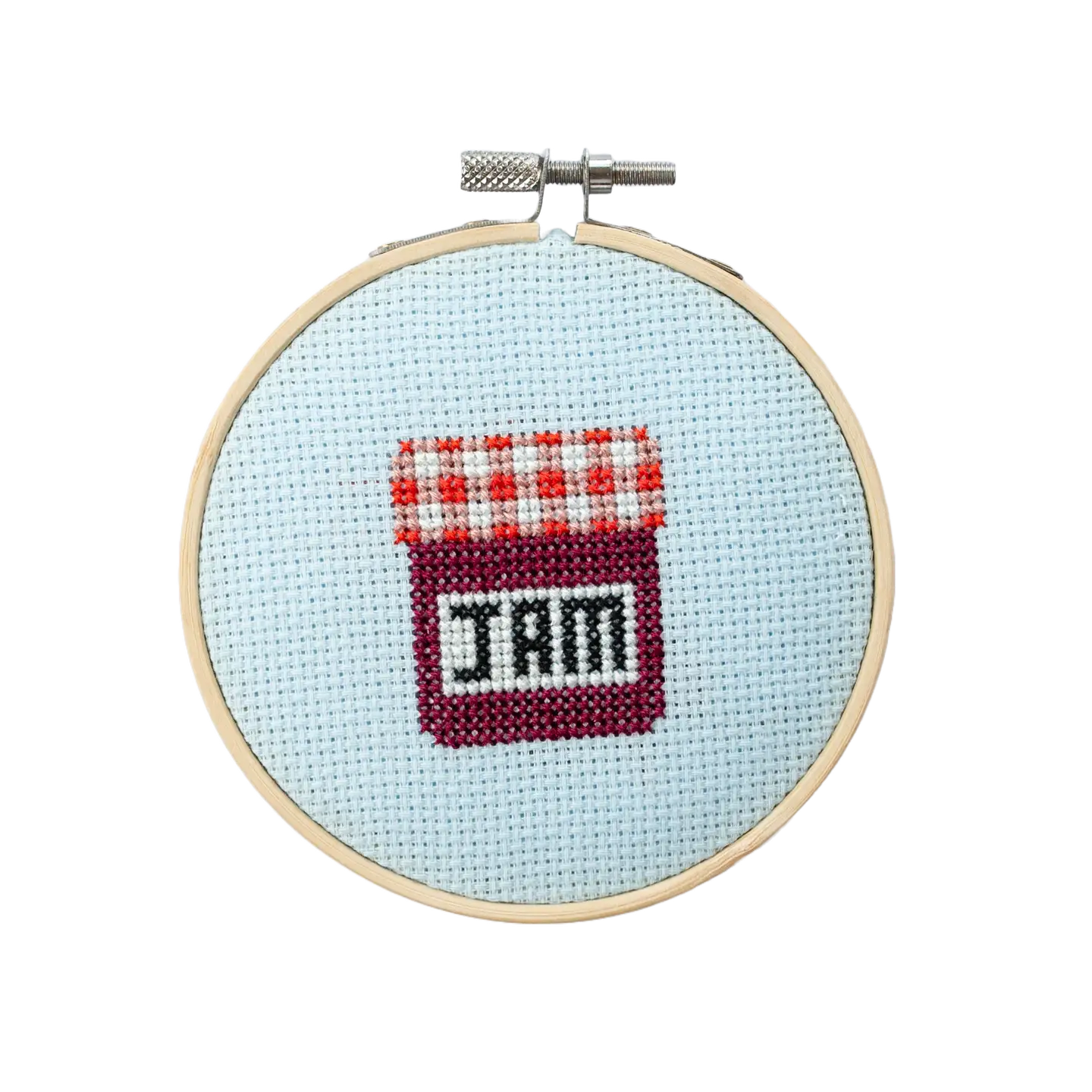 Cross-stitched design in a hoop with jam text on a light blue background