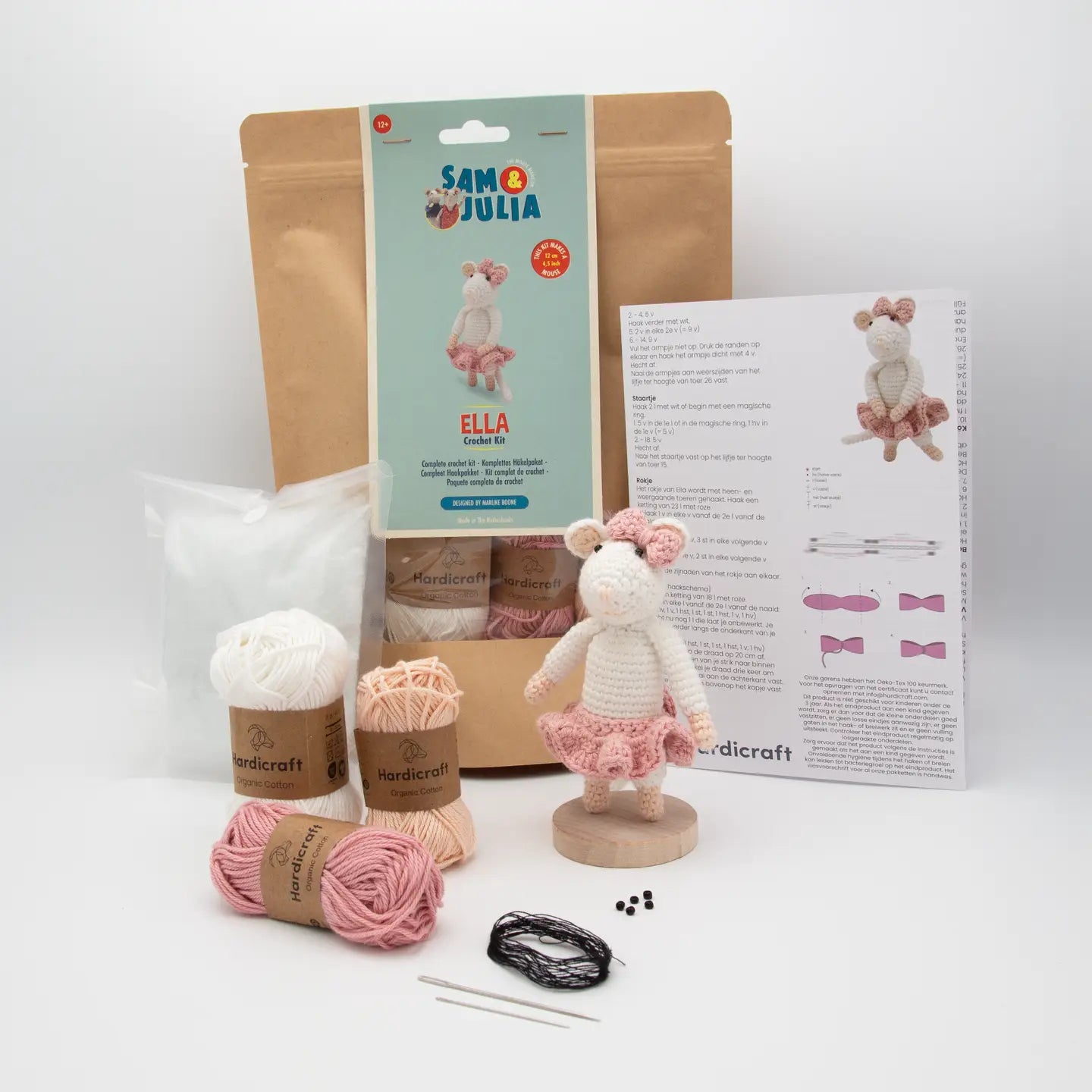 Knitting kit for creating a toy mouse with yarn, needles, and packaging on a white background