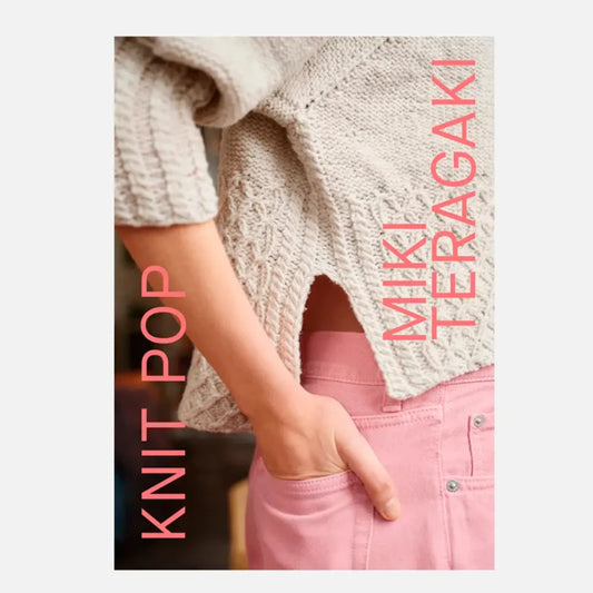 a cream textured knit sweater worn with pink pants