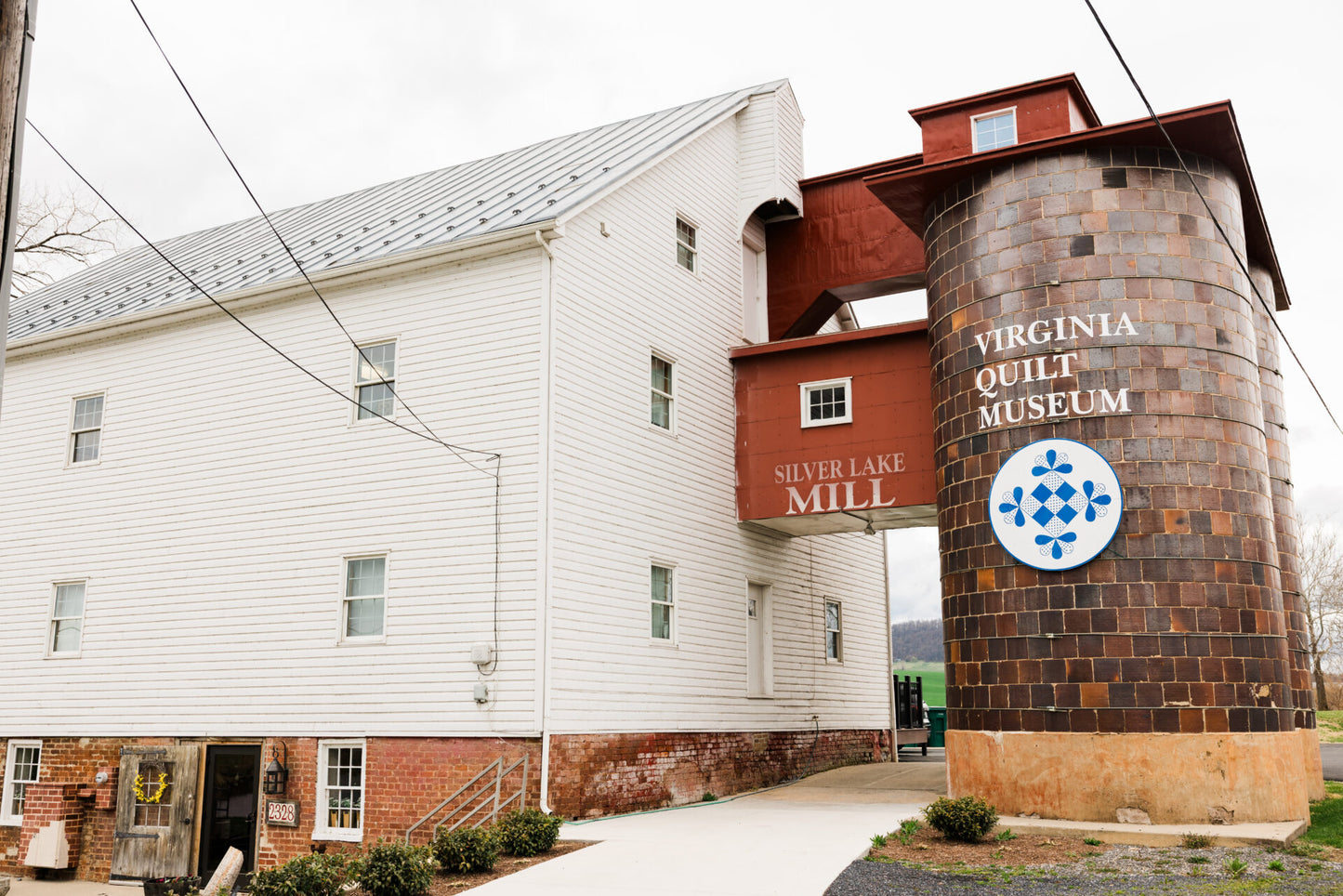 Virginia Quilt Museum building with a tall silo-like structure on a cloudy day.