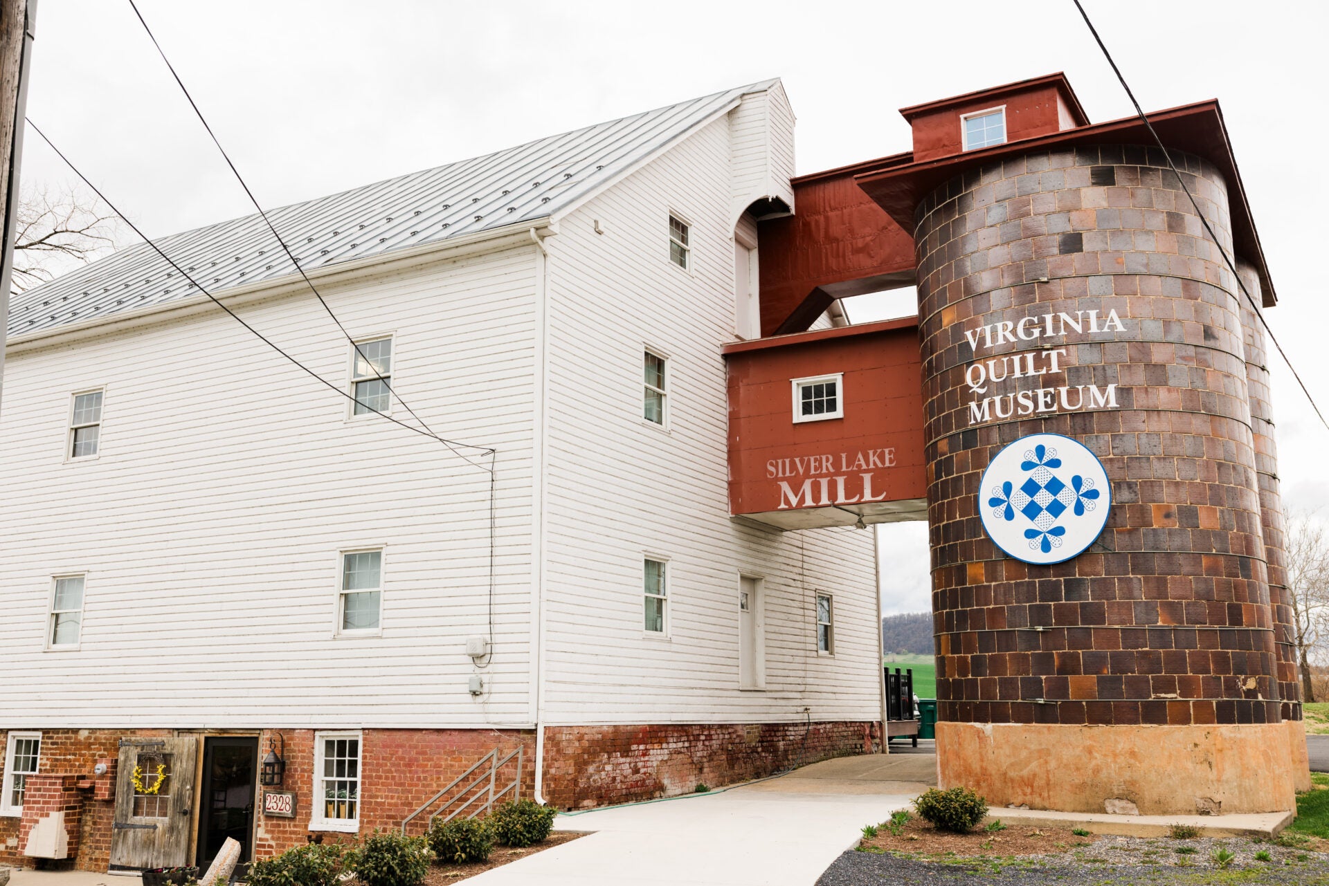 Virginia Quilt Museum building with a tall silo-like structure on a cloudy day.