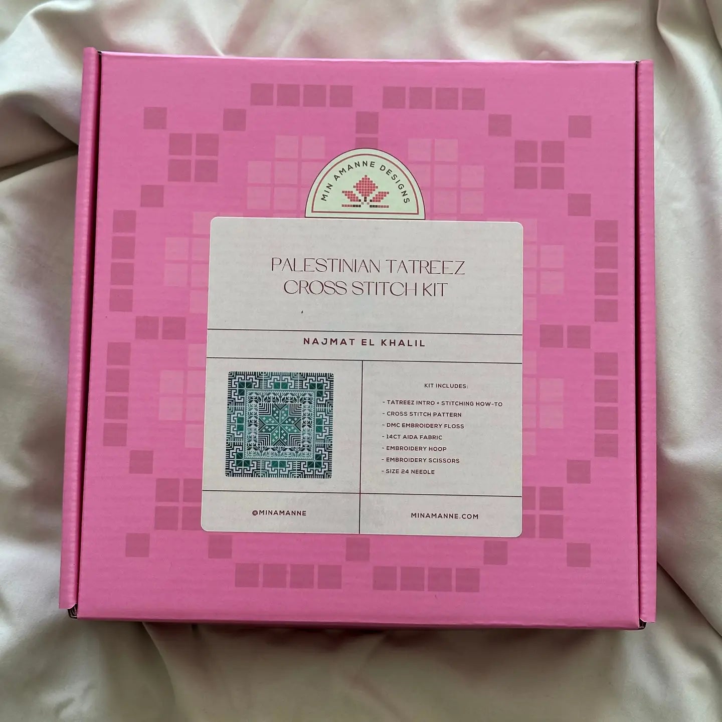 a pink box with a cross stitch embroidery kit