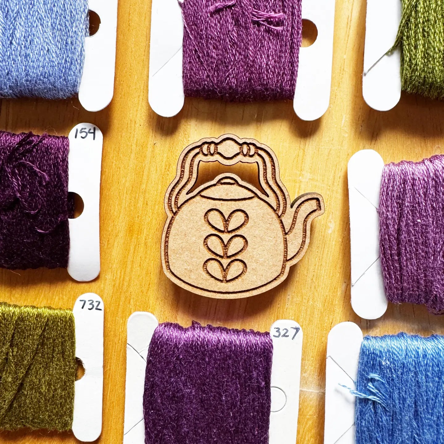 colorful thread  and a decorative teapot needle minder