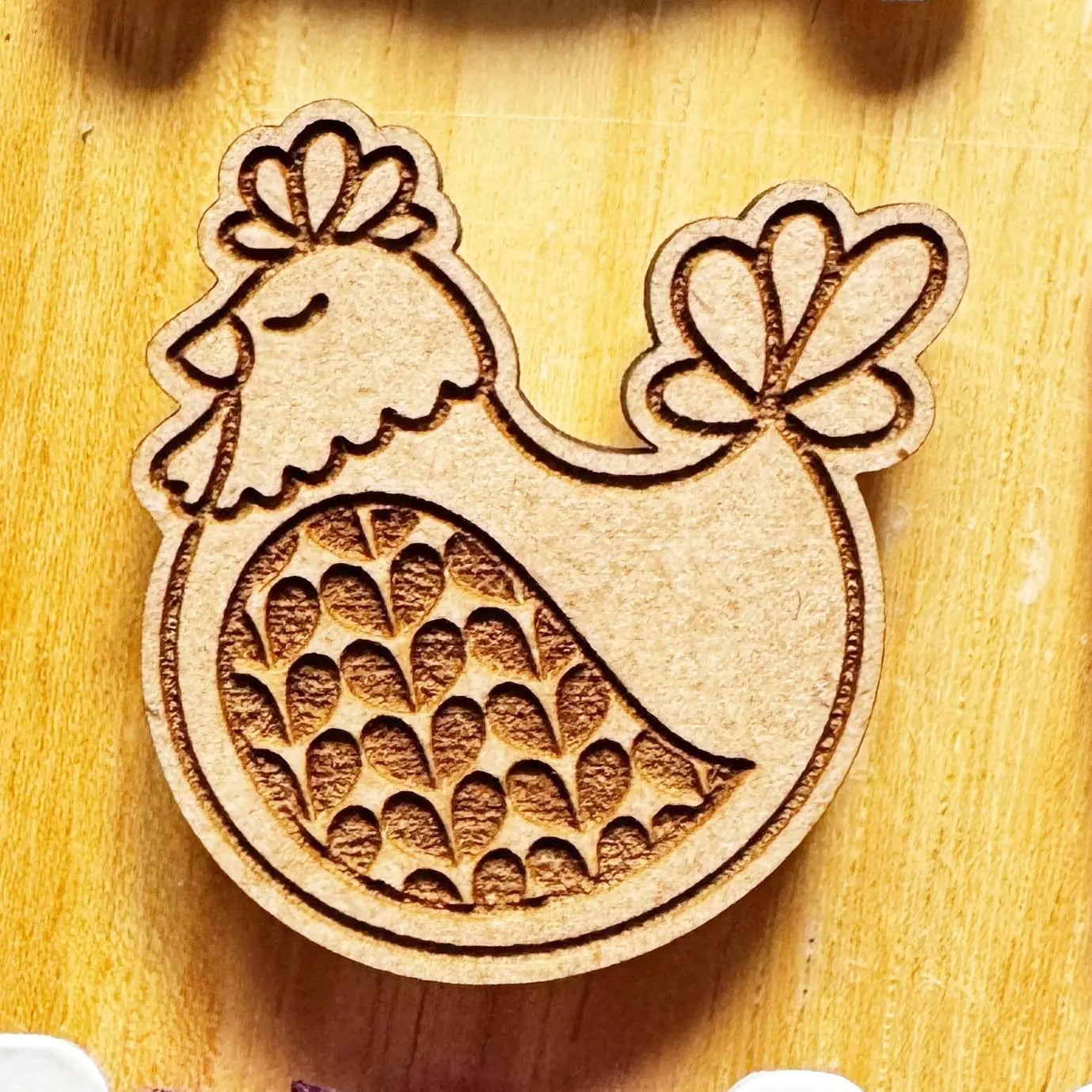 Wooden cutout of a rooster design on a wooden surface