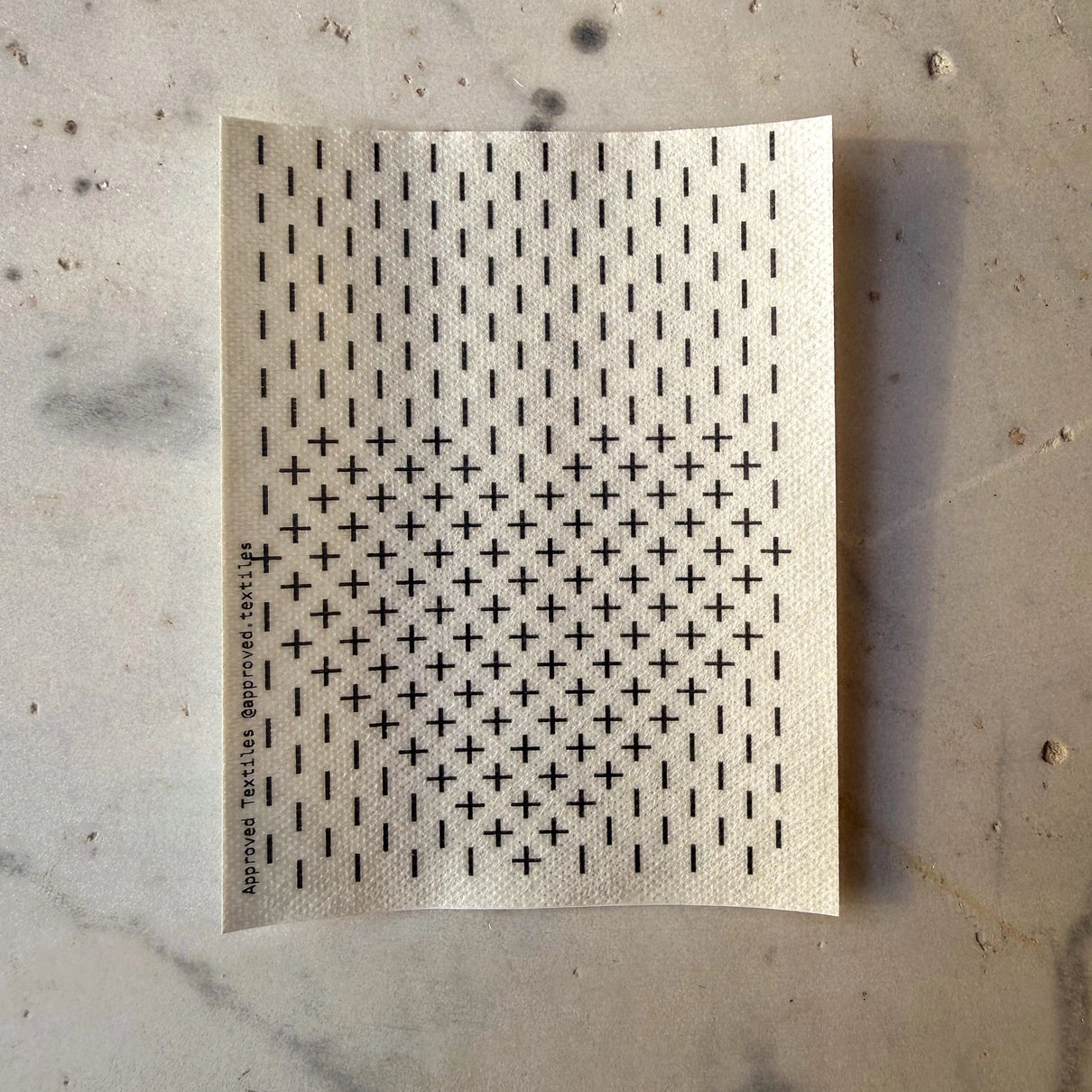 Sheet of black cross patterns on a textured beige background