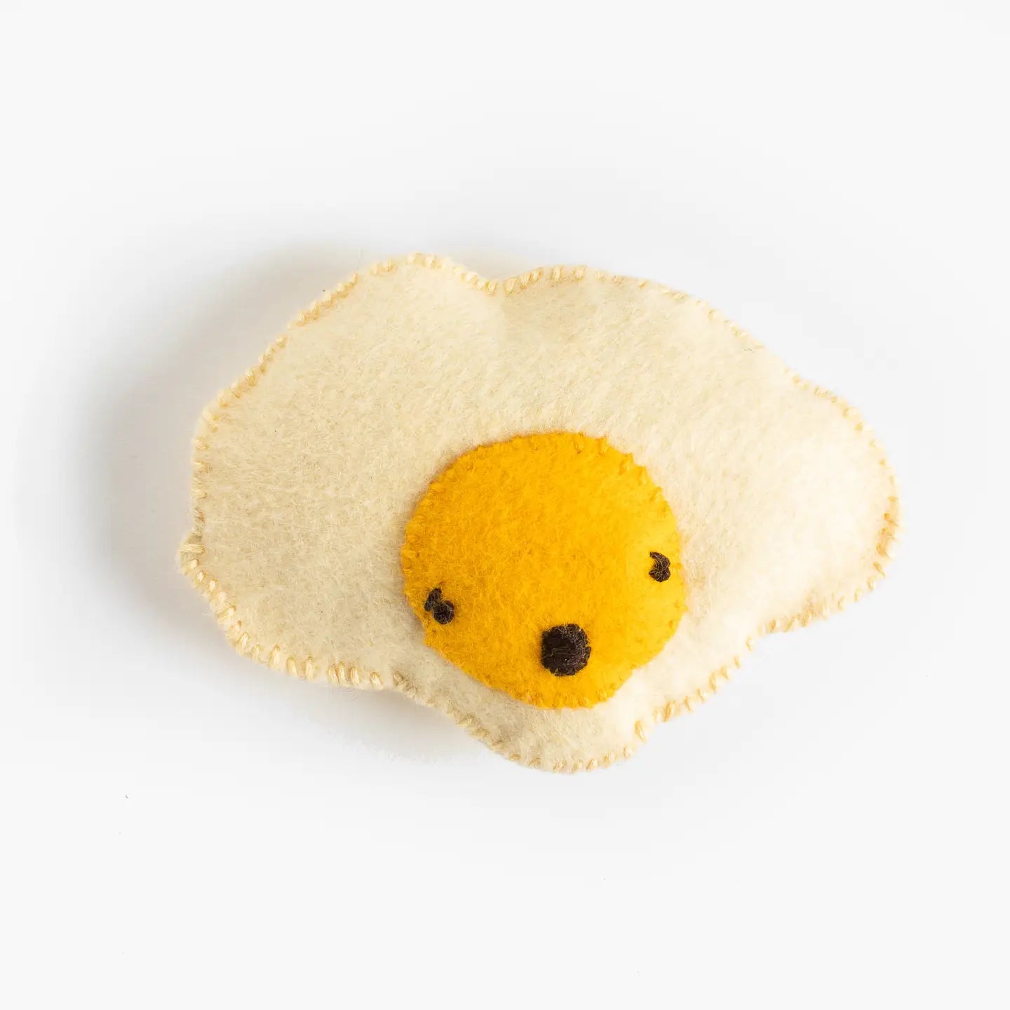 A hand sewn felt egg with a face on the yolk