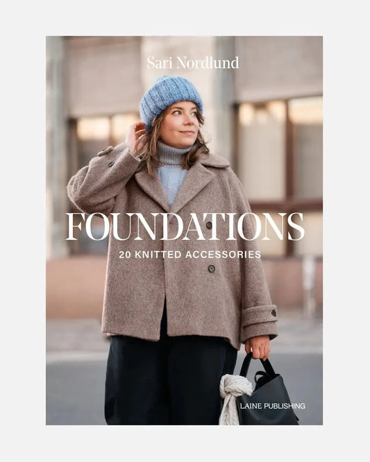 Book cover of 'Foundations' by Sari Nordlund featuring a person wearing a coat and blue beanie.