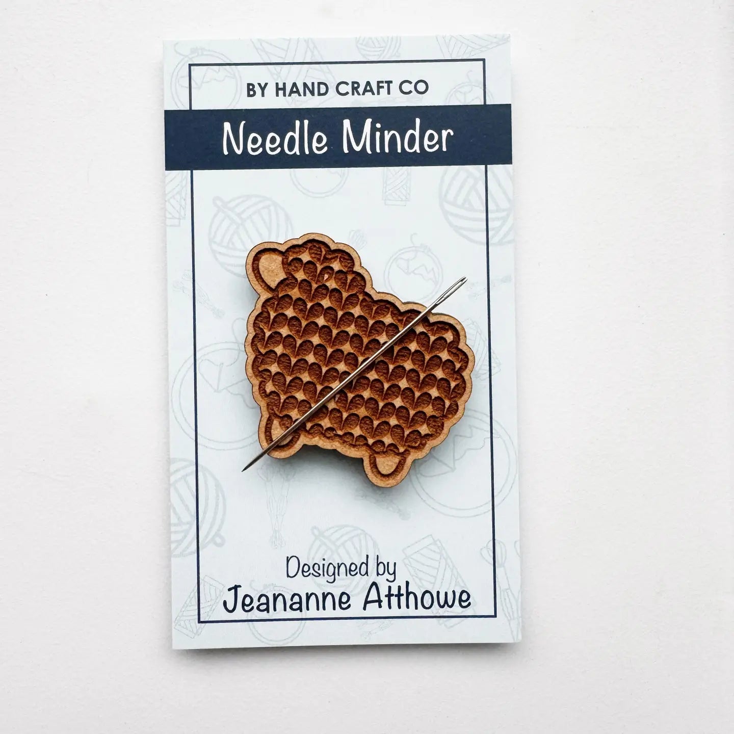 Wooden needle minder on a By Hand Craft Co branded card with a white background
