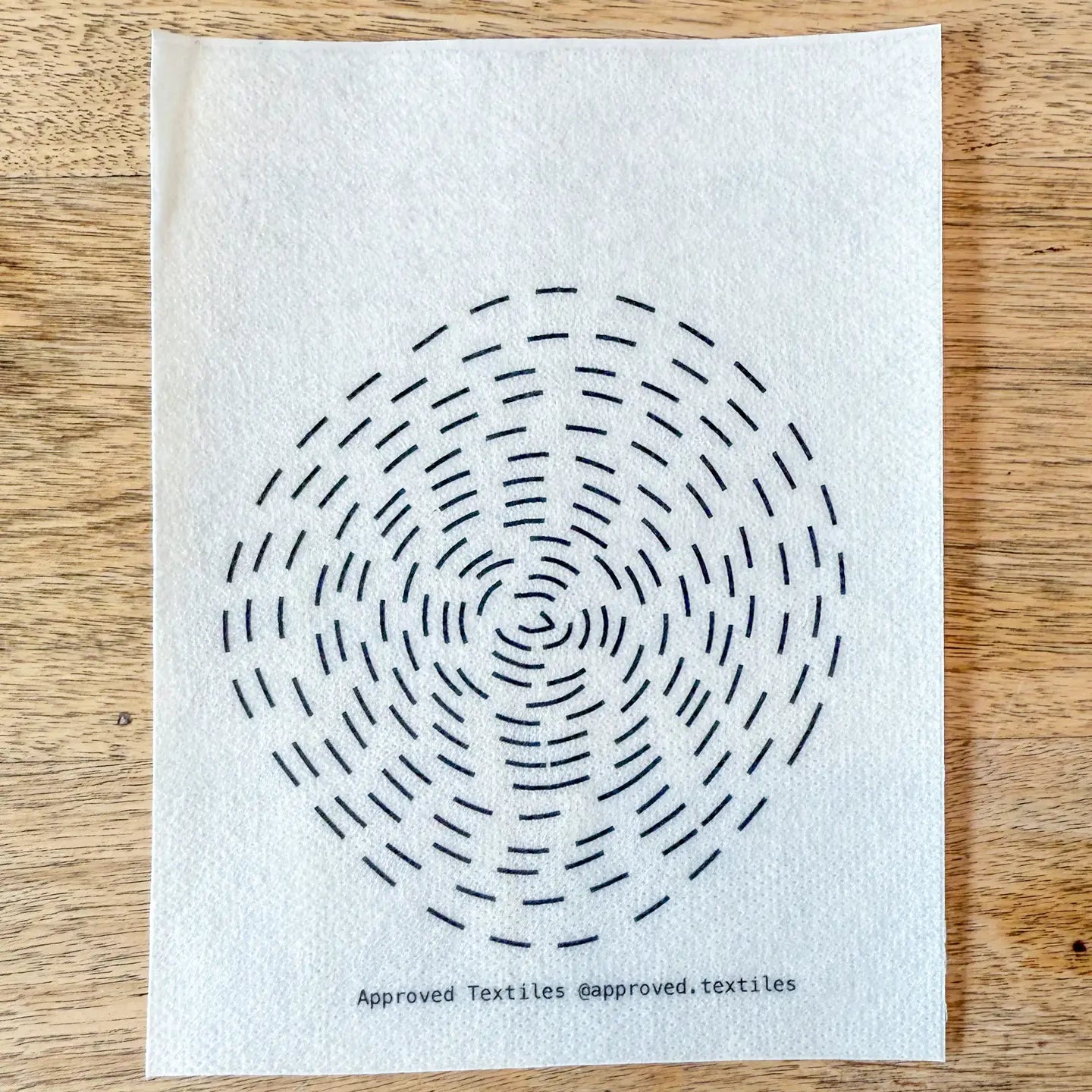 White paper with black circular pattern on a wooden surface