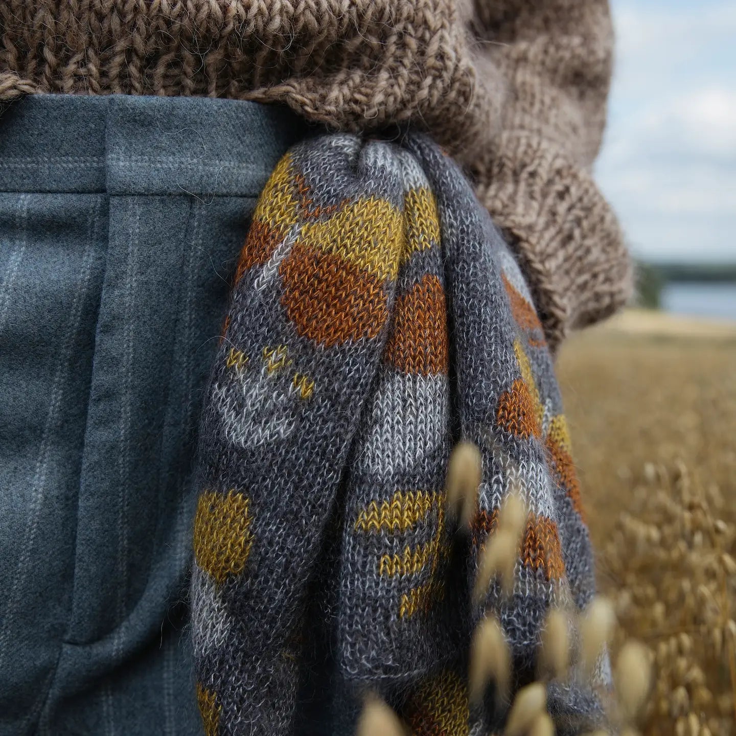 Orange and yellow butterflies on a gray knitted scarf