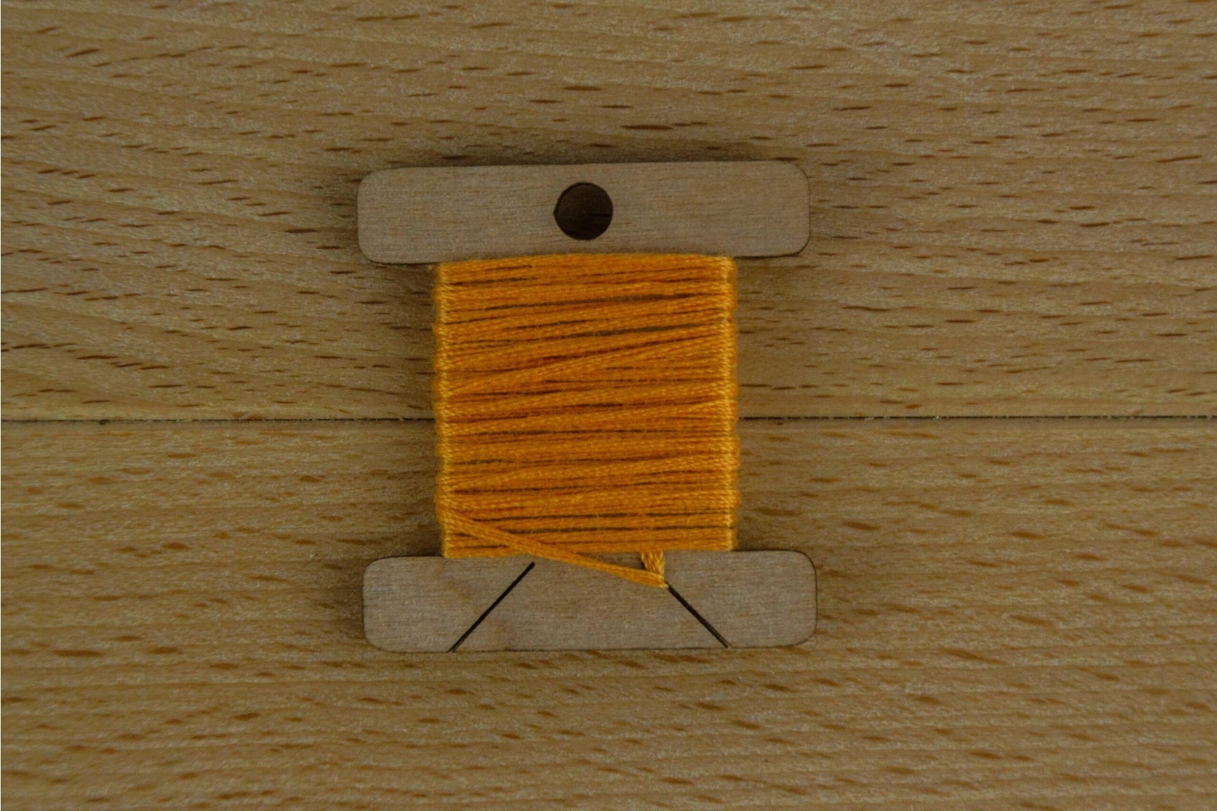 one wooden thread bobin wrapped with orange thread
