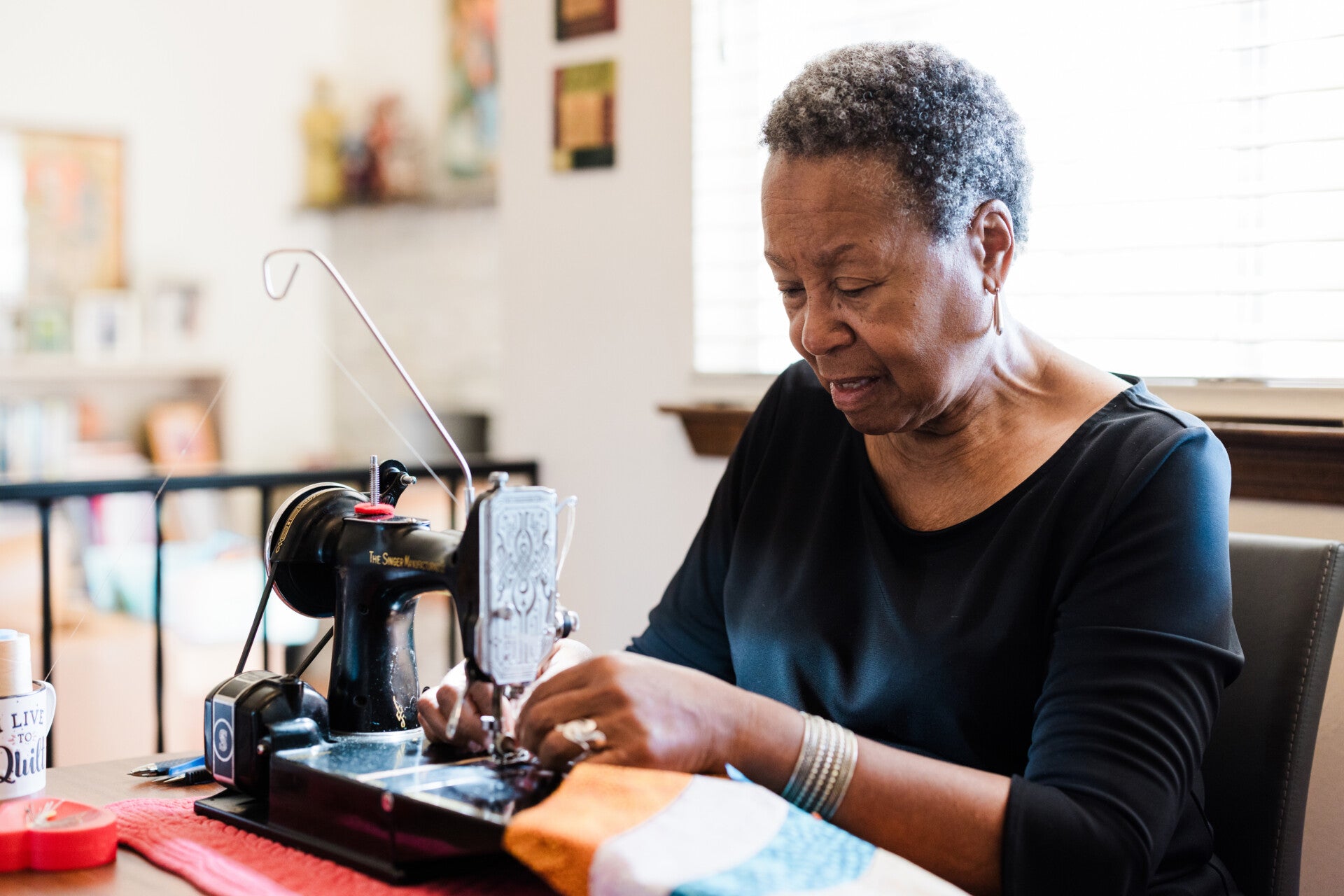 a woman sewing on a vintage sewing machine