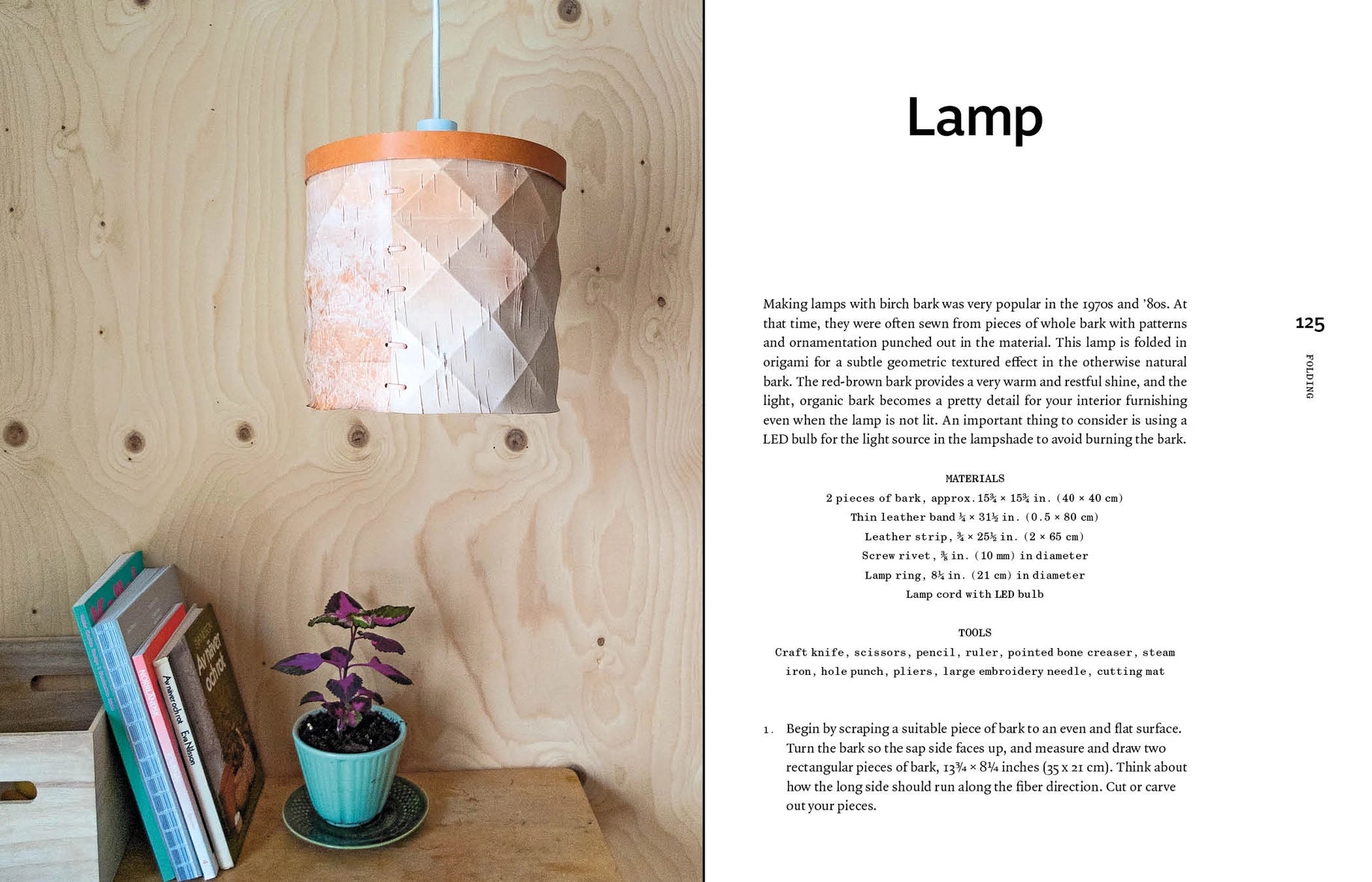 An open book spread showing a lamp project page. The left page features a handmade paper lamp with a peach-colored top and a blue decorative pot with a small purple plant.