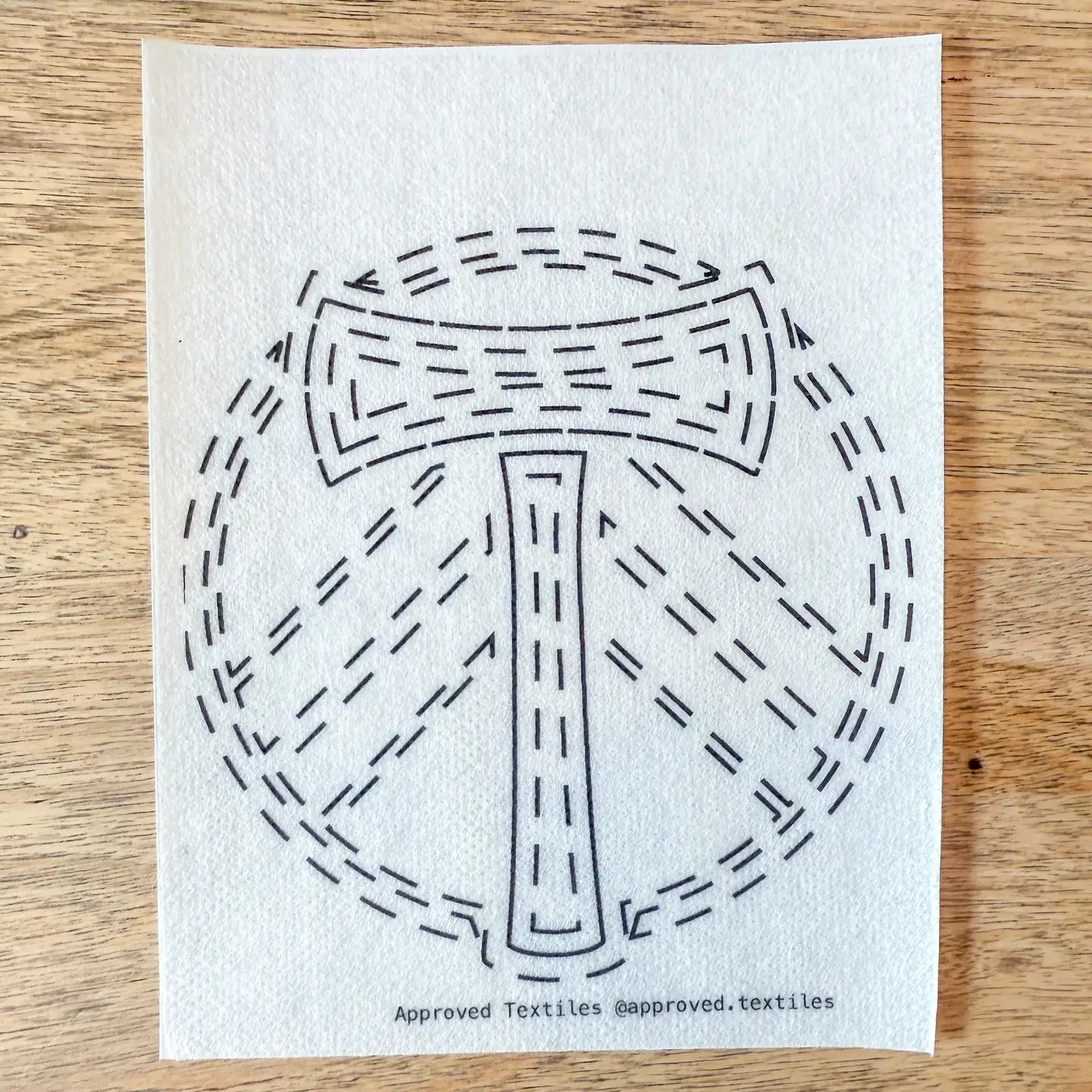 White cloth with black geometric design on a wooden surface