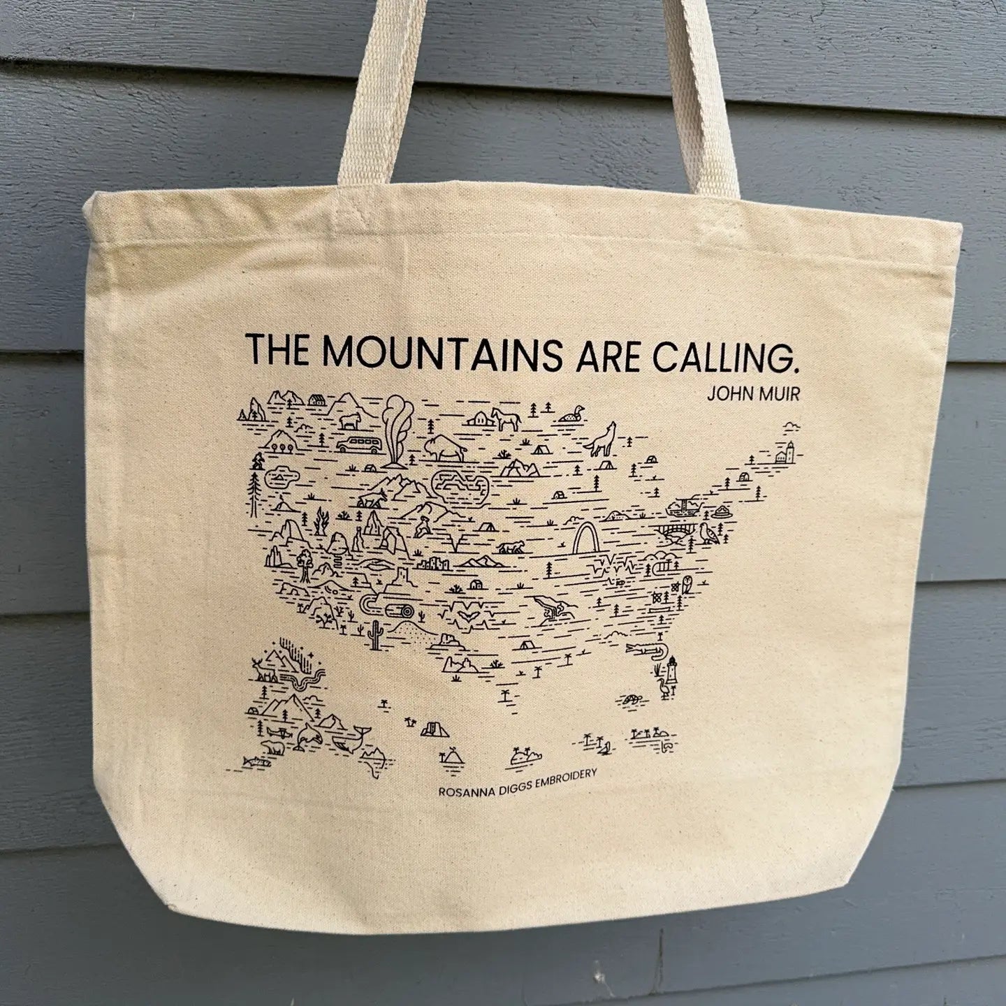 Beige tote bag with map design and text on a gray background