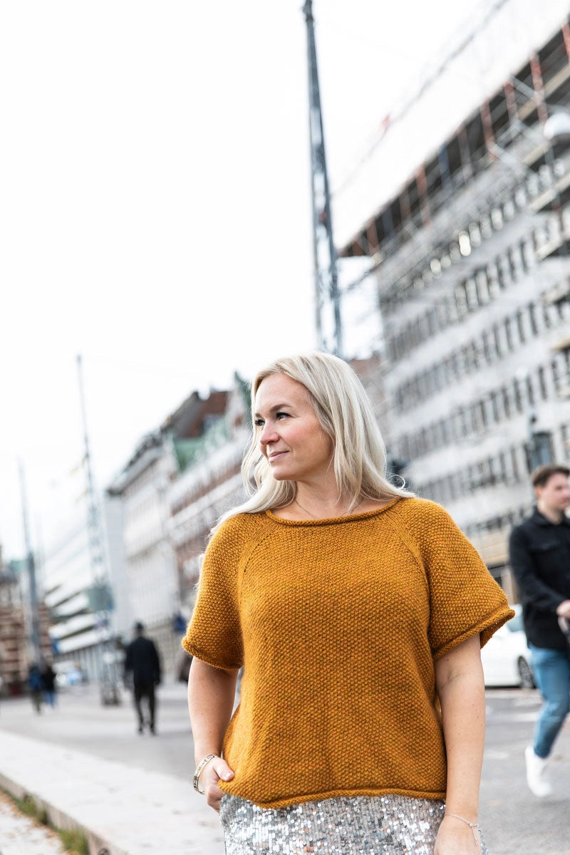 a mustard yellow short sleeve knit top