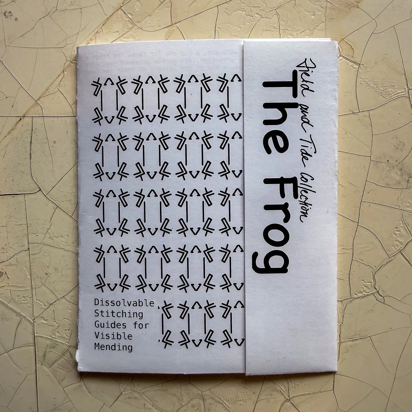 Booklet titled 'The Frog' with black text on a beige textured background