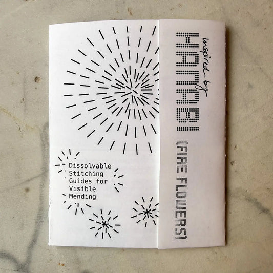 Booklet with black patterns and text on a textured surface