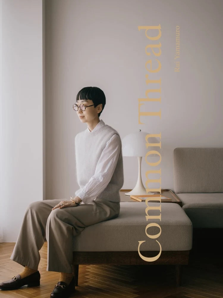  a person sitting on a sofa in a neutral sweater vest